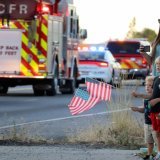 Des personnes ont rendu hommage aux pompiers décédés dimanche. KEYSTONE/AP/Bill Buley